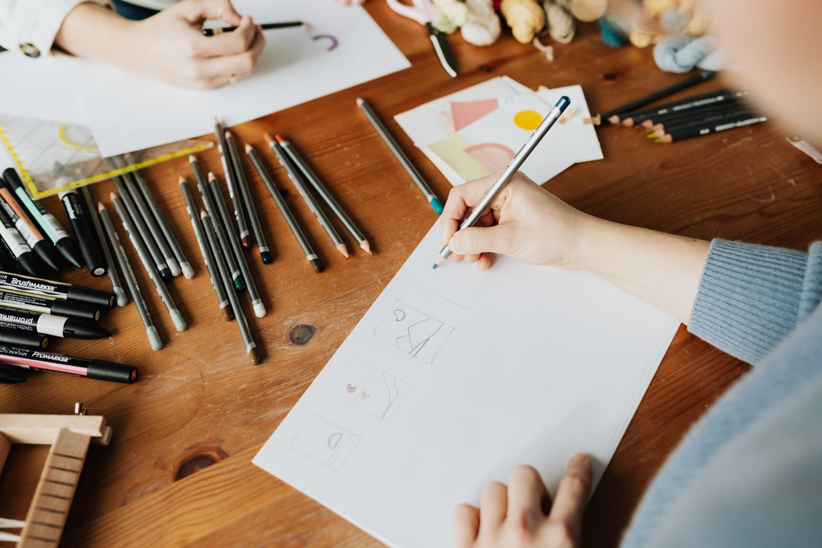 Deux designers dessinent des croquis au crayon pour concevoir un logo professionnel