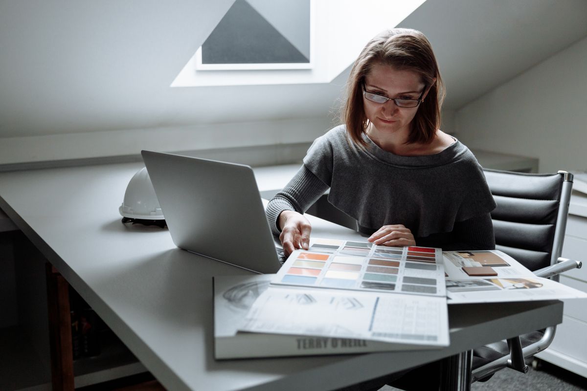 Designer comparant des nuanciers de couleurs à son bureau pour un logo d'entreprise
